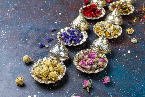 diverse tipologie di fiori dentro a contenitori preziosi argentati orientali